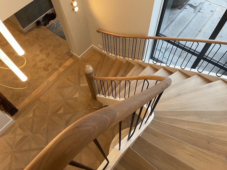 Moderne trap met houten trapleuning en metalen trapspijlen