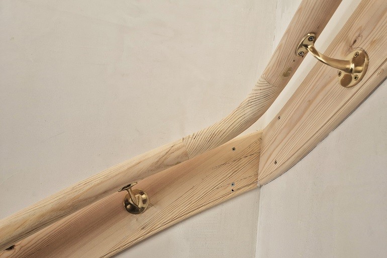 Grenen muurleuning op smet met beugels.